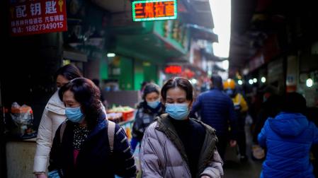 Varias personas caminan por las calles de Wuhan