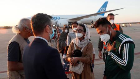 El ministro de la Presidencia, Félix Bolaños, da la bienvenida a la jugadora afgana de baloncesto en silla de ruedas Nilofar Bayat y a su marido a su llegada a la base aérea militar de Torrejón de Ardoz