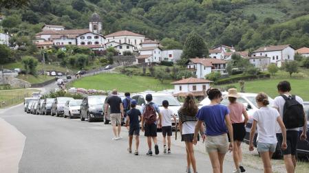 Un grupo de turistas se dirige a pie al centro urbano de Zugarramurdi