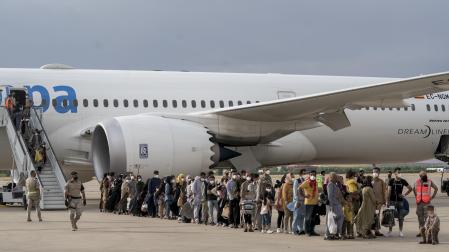 Varios refugiados tras la llegada de un nuevo avión a Torrejón