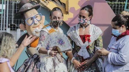 Varias falleras al lado de las fallas afectadas por las fuertes lluvias