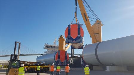 Carga en el puerto de Sevilla a bordo de un buque de las secciones que componen la mayor torre eólica