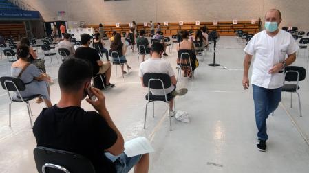 Varias personas esperan tras vacunarse en julio en el polideportivo de la UPNA