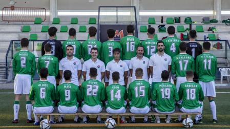 La plantilla del San Juan, que lucirá dorsal y nombre durante toda la temporada, posa de espaldas junto al cuerpo técnico.