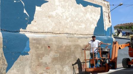El pamplonés Gabriel Coca, junto al mural que realizó en la calle Rey de Cintruénigo.