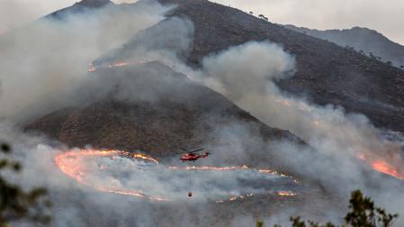 Un helicópetero trabaja en las labores de extinción del incendio de Sierra Bermeja