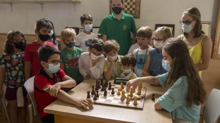 Javier Habans y Leyre Abarisqueta disputan una partida de ajedrez mientras sus compañeros de la escuela de ajedrez de Oberena miran