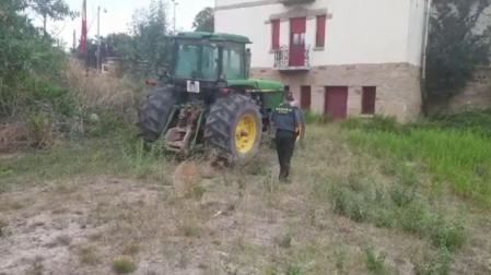 Un agente de la Guardia Civil, junto al tractor sustraído.
