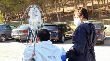La enfermera Elena Torres, con el paciente, en el exterior del hospital
