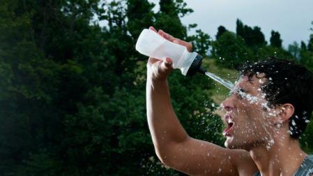 Un deportista, echándose agua