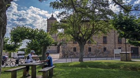 Dos ciclistas, en un merendero en el exterior del Monasterio de Irache