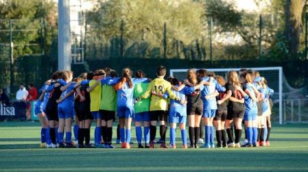 Las jugadoras de los dos equipos, abrazadas en el centro del terreno de juego