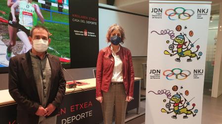 Primitivo Sánchez, subdirector del Instituto Navarro del Deporte y la consejera de Cultura y Deporte, Rebeca Esnaola, junto a un cartel con el logotipo y la mascota de los juegos