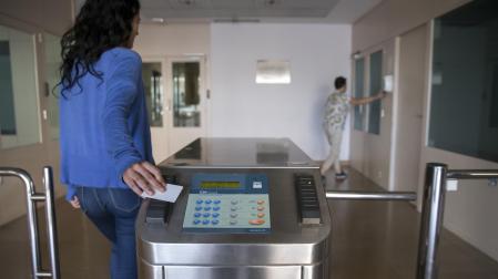 Una trabajadora registra su entrada a la empresa mediante un sistema de tarjeta de acceso