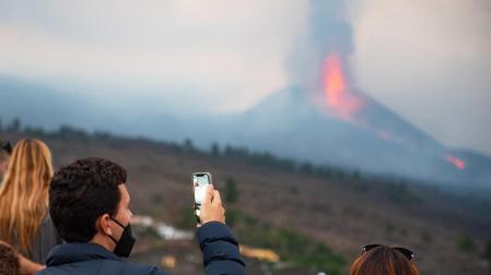 Varias personas y medios de comunicación en el mirador de Tajuya observando la erupción