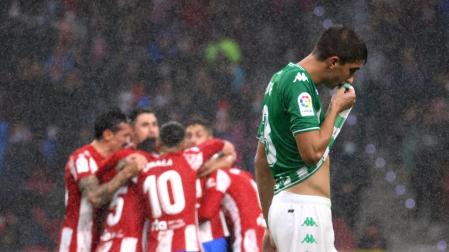 Los jugadores del Atlético de Madrid festejan el gol de Joao Felix delante del futbolista del Betis Edgar González