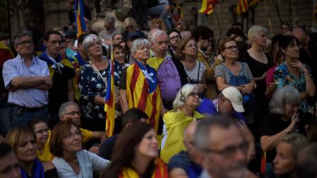 Independentistas catalanes escuchan a Carles Puigdemont en una pantalla de TV desde el Arco de Triunfo de Barcelona, el 10 de octubre de 2017