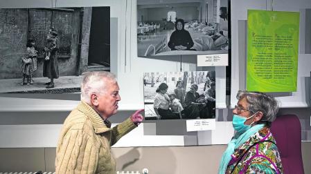 Dos personas comparten recuerdos en la exposición ‘Mujeres y cuidados’ en la Casa de Misericordia