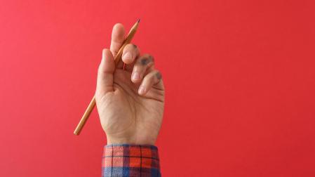 Un niño sujeta un lapicero con la mano izquierda