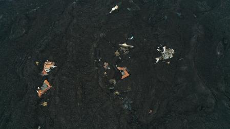 La fajana creada por la erupción del volcán Cumbre Vieja cubre algunas de las viviendas y parte de la carretera de un barrio cercano a la localidad de La Laguna