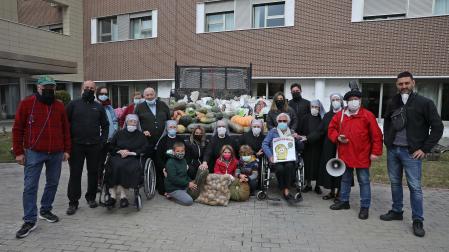 Hermanitas de los Pobres, residentes y los mozos de la peña Alegría posan con los alimentos recién llegados