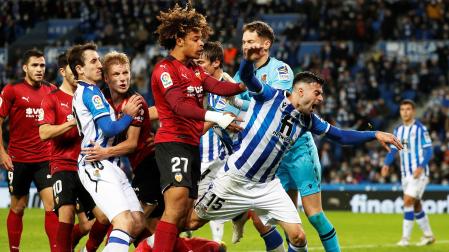 Jugadores de ambos equipos se enzarzan en el área de la Real Sociedad tras una jugada del tramo final del encuentro