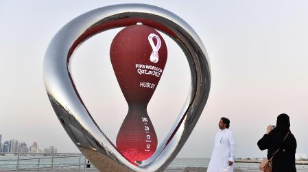 Dos personas se fotografían junto a un reloj de arena con al cuenta atrás para el comienzo del Mundiat de Catar 2022 en Doha