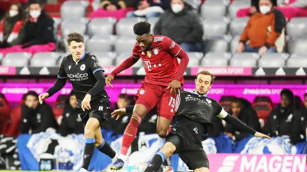 Davies, del Bayern Munich y Schopf, del Arminia Bielefeld, pelean por el balón durante el partido entre ambos equipos