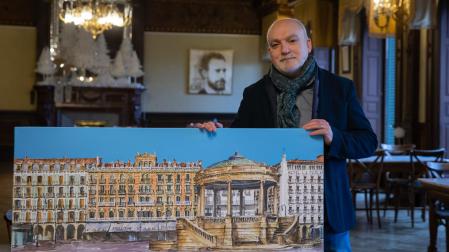 Alberto Marcos Yagüe, junto a una de las acuarelas de gran formato sobre la Plaza del Castillo, en la exposición instalada en el Nuevo Casino Principal.