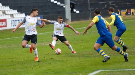 Santi Samanes, con el brazalete de capitán, trata de regatear a dos defensores del Real Unión