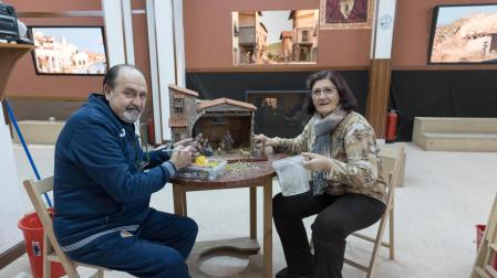 Félix Merino y Marisa Barrena trabajan en un Portal de Belén y ante tres de los dioramas que integran la exposición