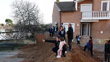 Varios vecinos de Buñuel contemplan la crecida del Ebro desde lo alto del dique de tierra levantado en la calle La Fuente