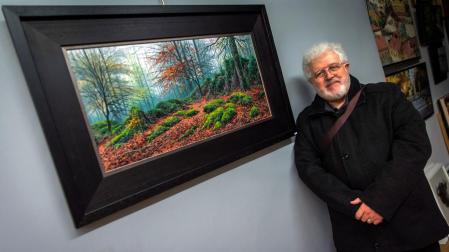 Joan Coloma posa junto a Hayedo de Urbasa, una de las obras de la exposición