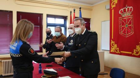 Una agente primera, recibe el diploma de finalización del curso