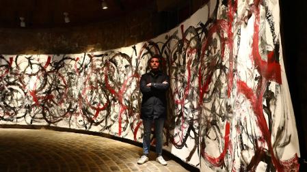 Yago Vaillo junto a la obra creada para el Horno, que ha pintado con la ayuda del movimiento de los pies de una bailarina de ballet.