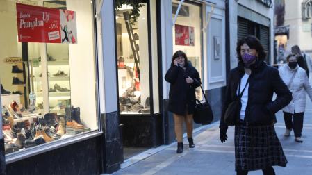 Varias personas, protegidas con mascarillas, caminan por el centro del Casco Viejo de Pamplona