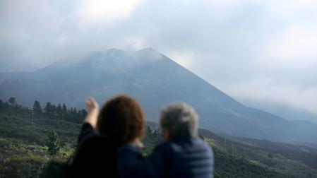 Dos mujeres observan el volcán de Cumbre Vieja, el día que se ha dado por finalizada oficialmente su erupción, desde el mirador de Tajuya