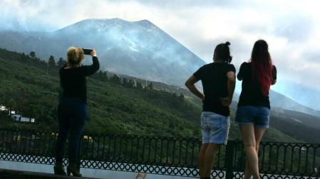Tres personas observan el volcán de Cumbre Vieja