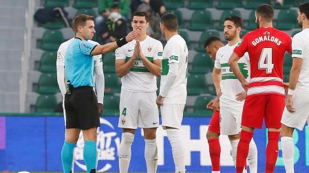 El árbitro Cordero Vega señala la salida al defensa del Elche Diego González tras sacarle la tarjeta roja