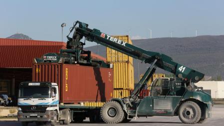 una grúa coloca un contenedor sobre un camión en la estación intermodal de Noáin