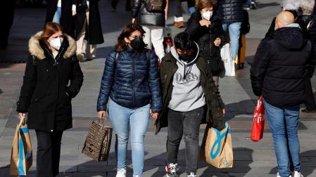 Varias personas con sus compras pasean por una zona comercial del centro de Madrid