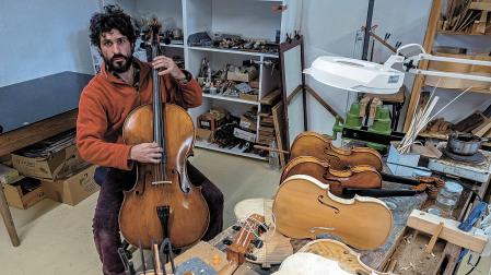 El luthier Iñaki Arguiñarena, con los instrumentos de cuerda en los que trabaja en este nuevo espacio