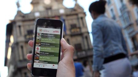 Una persona enseña una de sus aplicaciones móviles en la plaza del Ayuntamiento de Pamplona.