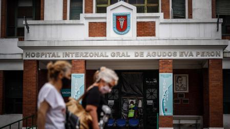 Dos personas caminan frente a la puerta del hospital de agudos, Argentina
