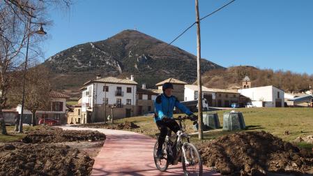Un ciclista circula por el nuevo camino peatonal de Las Eras de Monreal. Al fondo, la Higa