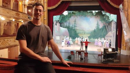 Iñaki Cobos, en el interior del Teatro Nacional de Croacia, con sede en Zagreb. Al fondo, la escenografía que ha diseñado para 'Giselle'