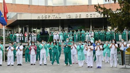 Personal de enfermería y otros profesionales sanitarios aplauden ante las puertas del Hospital 12 de Octubre de Madrid durante el confinamiento por covid-19 en abril de 2020.