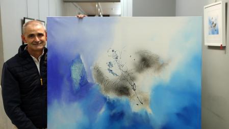 El artista Antonio Peña posa en la galería Michel Menéndez junto a la obra titulada Destrucción azul I.