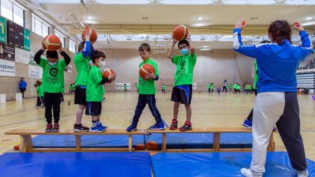 Seis escolares, de los sesenta participantes que hubo ayer en el Polideportivo Municipal de Noáin, practican el equilibrio supervisados por Nahia Ruiz, entrenadora del Club Baloncesto Noáin