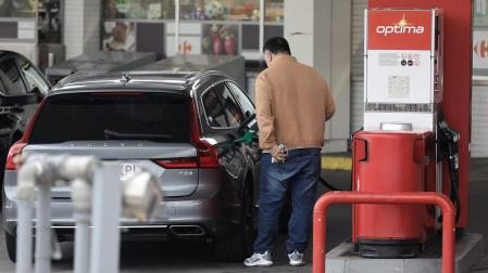 Una persona reposta combustible una gasolinera